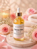 A bottle of My Unicorn Beauty Unicorn Diva Body Oil with a white dropper cap and gold collar, set on a marble coaster surrounded by pink roses, folded towels, pearls, and a candle.