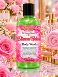 A bottle of My Unicorn Beauty Diamond Unicorn Body Wash with a green translucent body and a pink label, set against a luxurious pink and gold background with roses, crystals, and a towel.