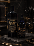 Two bottles of 'My Unicorn Beauty Royal Legacy' body wash and body oil on a dark surface with decorative elements.
