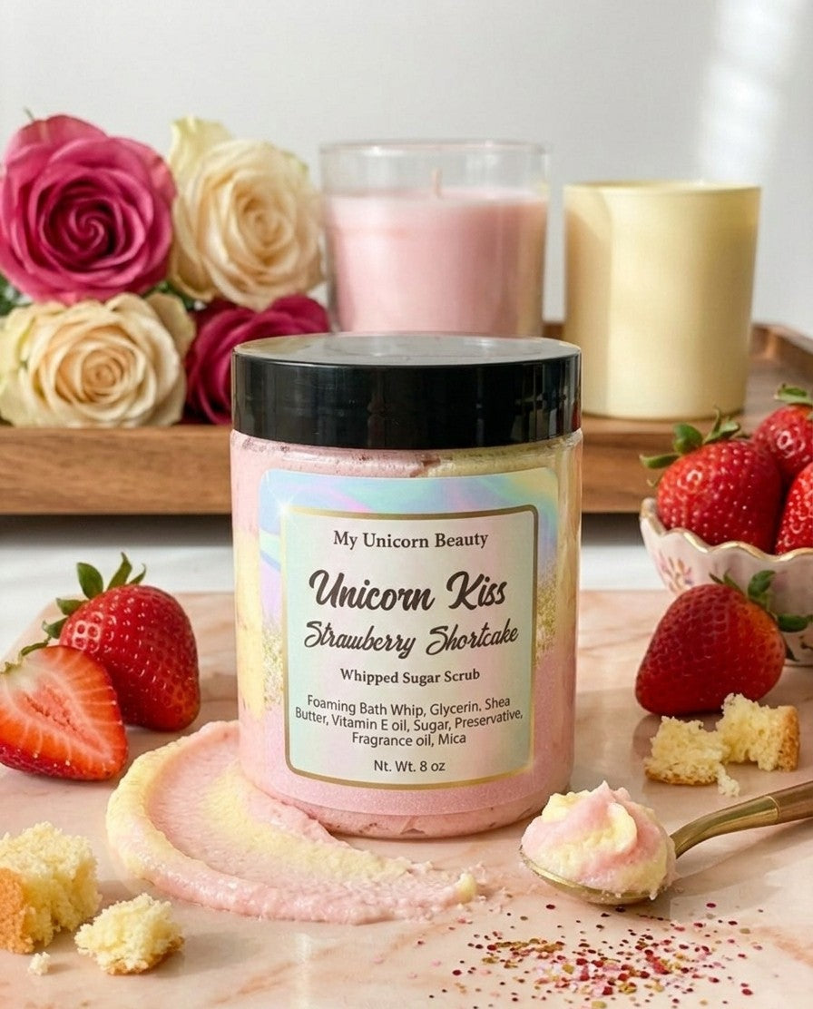Jar of 'Unicorn Kiss Strawberry Shortcake' whipped body scrub with strawberries and candles in the background