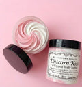 Unicorn Kiss whipped body butter jar with pink and white swirls on a pink background